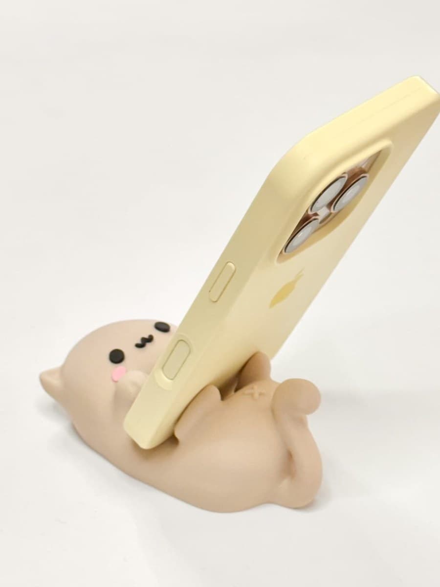 Cute cartoon cat character holding a phone as a phone stand